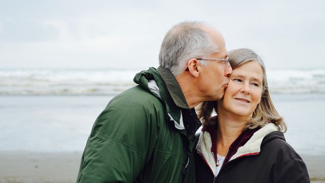 An elderly couple on the beach. 