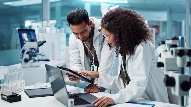 Two researchers looking at a screen. 