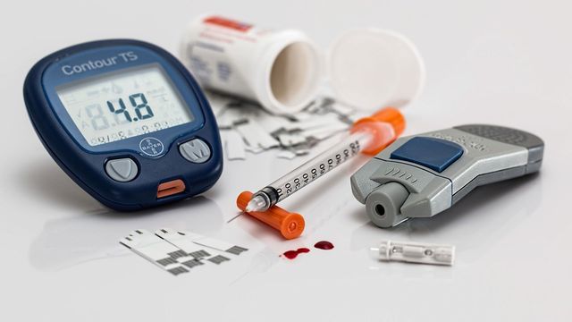 Blood glucose monitor with syringe of insulin and lance 