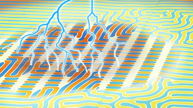 Lightning bolts strike a material with patterns resembling a computer chip. 