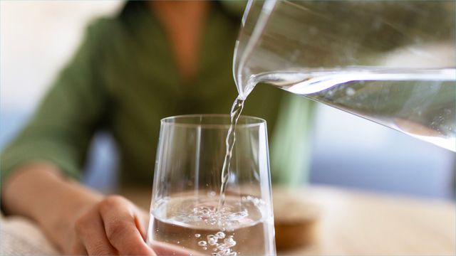 Drinking water being poured into glass 