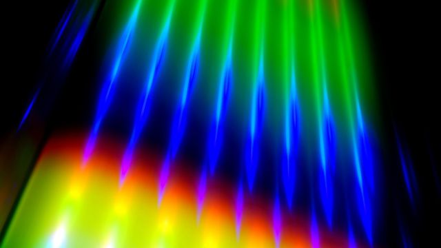 Multicolored light shining against dark backdrop 