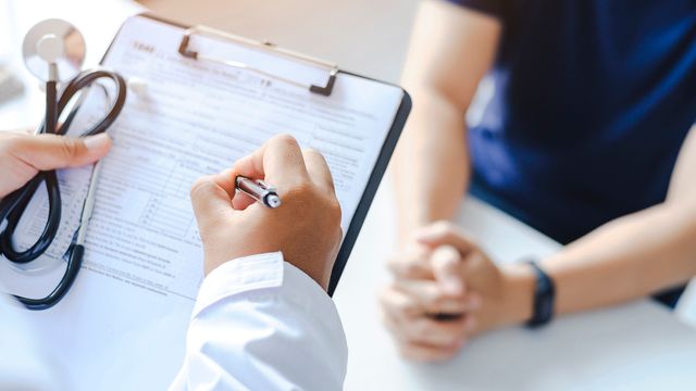 A doctor writing on a clipboard. 