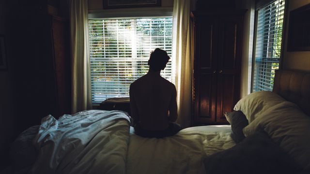 Person's silhouette sitting up in bed. 